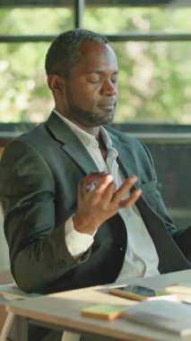 Şık bir çalışma alanında zihinsel refahı ve verimliliği teşvik ederek farkındalık uygulayan odaklanmış bir adam..