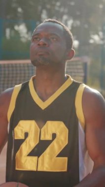 Kendini adamış ve tutkulu bir basketbolcu, akşam saatlerinde açık hava sahasında basket atmaya çalışır.