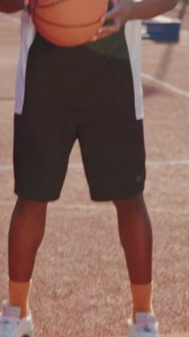 Adanmış ve odaklanmış bir atlet, spor ayakkabılarını ve canlı kıyafetlerini sergileyerek pistte hazır duruyor.