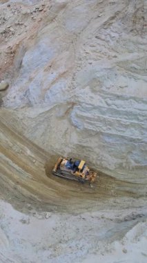 Bir inşaat sahasında aktif olarak çalışan ağır makineleri gösteren bir hava çekimi, arazi temizliğini vurguluyor