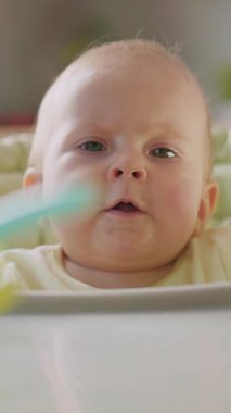 Meraklı bir bebeğin renkli bir oyuncağı zevkle keşfederken çekilmiş yakın plan görüntüsü.