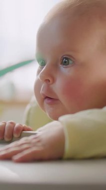 Engin bir merak ve neşe ile canlı çevrelerini gözlemleyen meraklı bir bebeğin hoş bir yakın çekimi.