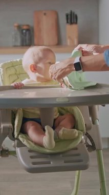 Sevimli bir bebek yüksek bir sandalyede mutlu bir şekilde oturuyor, eğlenceli ve ilgi çekici bir yemek saati deneyimi için her şey hazır.