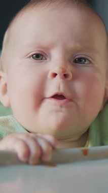 Masaya yaslanmış, saf merak ve masumiyeti canlandıran sevimli bir bebeğin enfes bir yakın çekimi.