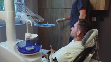 Modern ışık kliniğinde hastayı ameliyata hazırlayan dişçi. Hijyen ve sağlıklı.