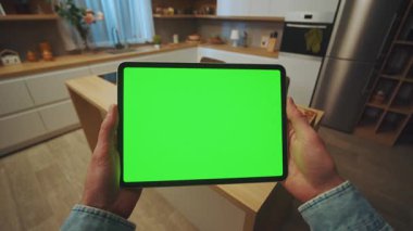 Mutfakta yatay yeşil ekranı olan tablet bilgisayarı tutan elleri kapat. Model ekran. Cihaz. Daire