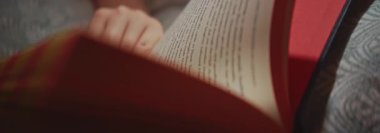 Güçlü bir nostalji hissi uyandıran canlı kırmızı kenarları olan açık bir kitabın büyüleyici yakın plan görüntüsü.