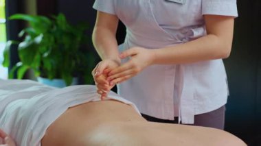 Tanımlanamayan genç bir kadın masözün kaplıca merkezinde esmer bir bayana masaj yapması. Sağlıklı yaşam tarzı ve vücut bakımı kavramı. Rahatlayın ve sağlığınıza bakın. Kapalı