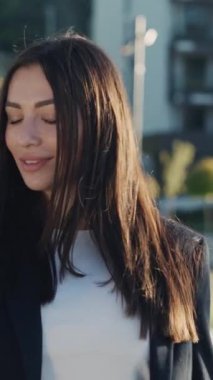 İş kadını genç çekici ve gözlüklü bir kadın şehir merkezinde gün ışığında telefonla dolaşırken etrafına bak ve mutlu ol. Cep telefonu olan bir portre kızı. Yavaş çekim