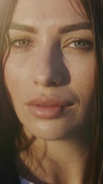 Şehir merkezindeki kameraya gün ışığında bakan çekici bir kadın portresi. Açık yüzlü kız. Rüzgârlı. Yavaş çekim