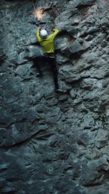 Parlak spor giyim kuşağıyla yüksek kayalara tırmanan profesyonel sporcu görüntüsü. Dağ görüntüleri. Tırmanma aktivitesi. Yürüyüş.