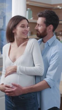 Gelecekteki sevecen anne babaların neşeli beyaz çifti hamile eş ve kocalar modern şık ev mutfağında ultrason fotoğraflarını izliyorlar..