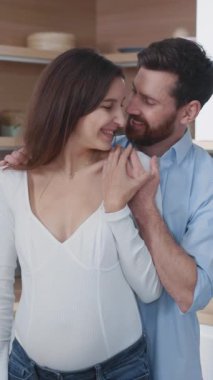 Kafkasyalı bir çift neşeli karı koca hamilelik haberlerini arkadaşlarıyla görüntülü sohbet ederek paylaşmayı bekliyor. Laptop mutfakta. Aile hayatı. Ebeveynlik.