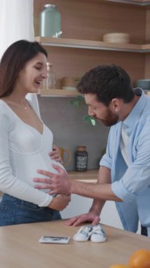 Müstakbel ebeveynler mutfakta iletişim kuruyor. Kocasıyla karnını doyuran hamile, beyaz bir kadın. İlişki. Aileler.