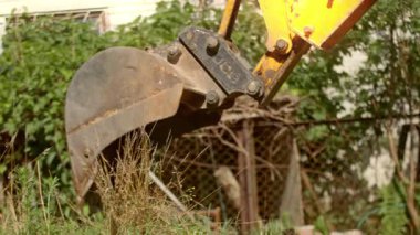 Bu video açık hava inşaatı sergiliyor, toprak yığını ve çitle başlıyor, sonra bir kazıcı kazıyor, gücünü ve hassasiyetini vurguluyor.