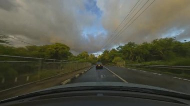Bu video bereketli ağaçların arasından geçen dolambaçlı bir yolda bir arabayı ön cama vuran hafif yağmur gibi sükuneti gösteriyor.