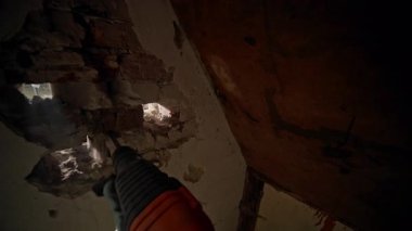 Bu görüntü, hasar görmüş bir duvar üzerinde çalışan bir matkabın kentsel yenilemede yakın çekimini gösteriyor.