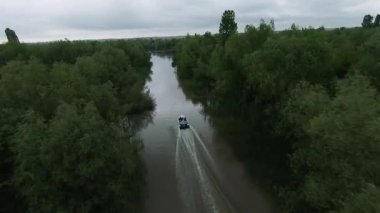 Drone FPV kırsal doğa üzerinde uçuyor. Gençler tekneyle Vahşi Nehir 'i geçiyorlar. Yelkenlide geleceğin robot prototipi. Macera dünyası. Nesnelerin interneti.