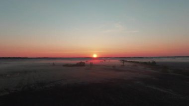 Kalın sis bulutlarıyla kaplı muhteşem tarlaların üzerinden uç. Uçan dronlu güzel doğa manzarası. Gün batımı manzarası. Hava saldırısı..