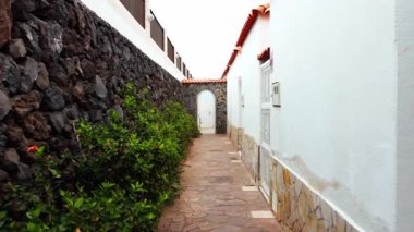 Yaz günü tropikal İspanyol evinin güzel, parlak avlusu. Bitkiler, taşlar ve beyaz duvarlarla mükemmel bir dış görünüş. Yazlık villa. Tatil kavramı.