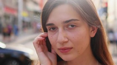 Gülümseyen, neşeli bir kızın açık havada çekilmiş portresi. Sokak manzaralı neşeli duygusal genç kadın. İnsanlar ve ifadeler.