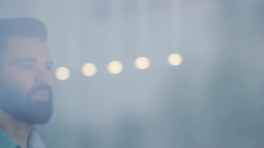 Kahve içen genç bir işadamı ve ofis penceresinin yanındaki manzaraya hayran olan yakışıklı patron çay içen Kafkas görünümlü genç yönetici rahatlama görüşünü yavaş çekimde gözlemliyor.