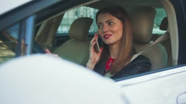 Los Angeles, California 15 / 03 / 2019 EDITORIAL: Saf genç kadın sürücü koltuğunda oturuyor ve elinde akıllı telefonu tutuyor, arıyor. Erkek arkadaşıyla konuşan sıkı bir kızın portresi. Sokak. Araba, araç, etnik köken, neşeli