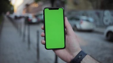 NEW YORK - 19 Nisan 2019: Dikey yeşil ekran mobil arka plan araba şehir görüntüsü bulanık kromaanahtar değiş tokuş eden dokunmatik ekran açık hava iş dünyası internet dokunuşu yavaş çekim