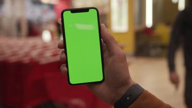 NEW YORK - 19 Nisan 2019: Eller havada dikey yeşil ekranlı akıllı telefonu kullanır şehir içi renkli açık arkaplan iletişim cihazı dijital cihaz telefon dokunmatik mobil yavaş çekim