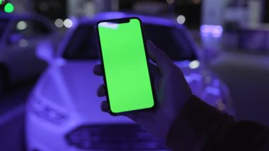 NEW YORK - 19 Nisan 2019: Gece şehir mavi ışıklı arka plan beyaz araba iletişim aygıtı dokunmatik mobil yavaş çekimde akıllı telefon kullanımı