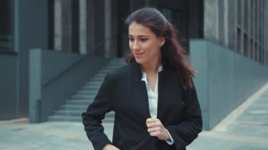 Güzel görünümlü esmer kadın ofisten çıkıyor. Akıllı telefonunu alıyor. Zaman çizelgesini kontrol ediyor..