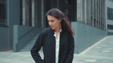 Ofis dışındaki beyaz kadın esmer kız akıllı telefon alıp sosyal medya haberlerini kontrol ediyor. Şaşırmış bir yüz ifadesi var..