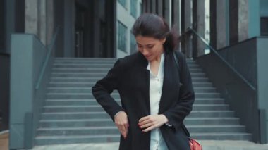 Mutlu çekici bayan yönetici ofis binasından çıkıyor. Telefonlara cevap veriyor. Kafkasyalı neşeli genç bayan dışarıda akıllı telefondan cep telefonuyla konuşuyor..