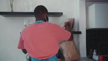 Yetenekli bir şef, hem modern hem de organizasyon tarzını geliştirmek için mutfak malzemelerini düzenli olarak raflarda düzenliyor.