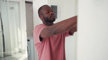 Hippi evden çıkarken kulaklık ve ceket takar, giyinir, dışarı çıkar. Aynanın önünde..