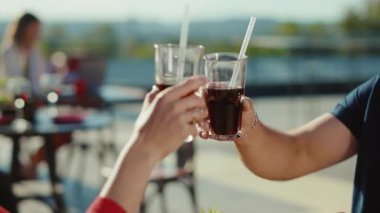 Şirin, genç, rahatlatıcı kadın ve erkek kokteyl içerek ve sokak kafesinde hamburger yiyerek yemek kız arkadaş yemeği, neşeli, yavaş çekimde portre.