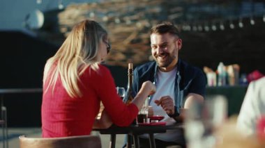 Gün ışığında, genç bir adam ve kadın, sokak kafesinde kokteyl içerken, birlikte yemek yerken, kız arkadaş yemek yerken, ağır çekimde neşeli portreler çekerken,