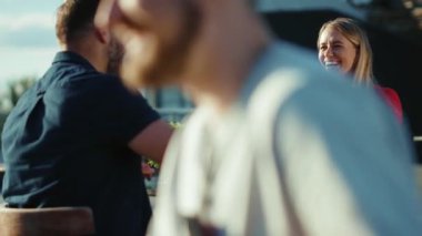 Güneşli bir günde, genç bir adam ve bir kadın sokak kafesinde kokteyl içerken, birlikte yemek yiyor, kız arkadaşlarıyla yemek yiyor, ağır çekimde neşeli portreler çekiyor.