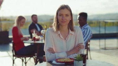 Mutlu, güzel bir kadının portresi. Dışarıdaki kafede gün ışığında kameraya bakıyor. Günlük yaşam tarzı.