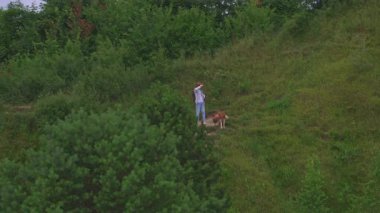 Sibirya köpekli beyaz bir genç adam tepe parkında yürüyor. İnsan ve köpek birlikte dışarı çıkar..