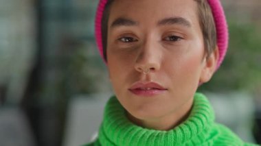 Kapalı alandaki kameraya bakan ela gözlü, ikili olmayan modelin yakın çekimi.