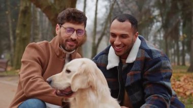 İki mutlu, çok ırklı eşcinsel oyun oynuyor ve parkta köpek besliyor. Lgbt kavramı