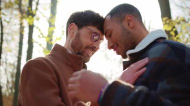 Eşcinsel çift şefkati anı. Bulanık arka planda çok ırklı homoseksüel erkekler