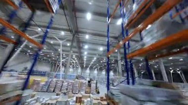 Depoda hızlı FPV uçuşu. Manevra edilebilir helikopter görüntüsü modern lojistik merkezi dağıtım ürünü dağıtım binası içinde.
