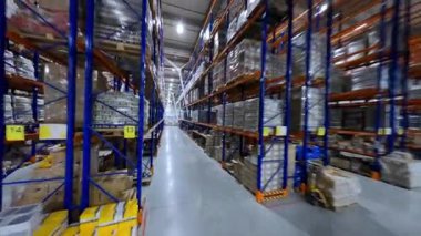 Depo binasında FPV uçuşu. Lojistik merkezi. Ürün dağıtımı için büyük bir endüstriyel takım yıldızı. Teslimat. Perakende deposu. Manevra kabiliyeti.