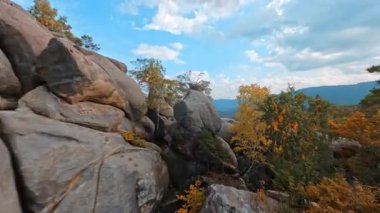 Ukrayna, Dovbush Kayaları. Aktif Kafkasyalı meraklı bir çift genç yürüyüşçü kayaların üzerinden tırmanıyor. Yürüyüş aktivitesi. Olağanüstü bir macera. Seyahat kavramı.