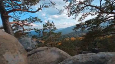 Ukrayna, Dovbush Kayaları. Etkileyici turistik cazibe. Seyahat güzergahı. Kafkasyalı birkaç genç yürüyüşçü erkek, kaya taşlarına tırmanıyor..