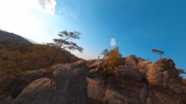 FPV Dovbush Rocks 'un manevra kabiliyeti olan video görüntüleri. Muhteşem bir seyahat noktası. Kayalara atlayan aşırı kaygısız hippi turist. Aktif yürüyüş. Seyahat.