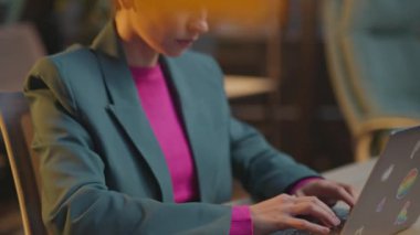 Pembe saçlı portre kadını, ofiste ciddi LGBT çıkartmalı dizüstü bilgisayar kullanıyor.