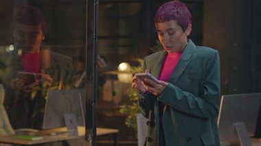 Ofiste pembe saçlı, üzgün genç bir kadın telefon kullanıyor. Geceleri baş ağrısı çekiyor. LGBT